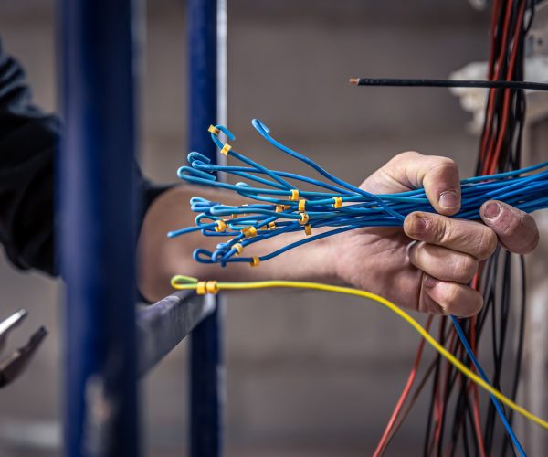 a-male-electrician-works-in-a-switchboard-with-an-electrical-connecting-cable-1-1-3